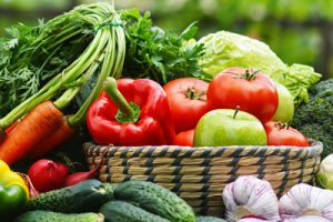 Fresh organic vegetables in wicker basket in the garden