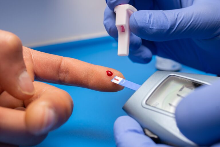 Closeup shot of a doctor with rubber gloves taking a blood test from a patient