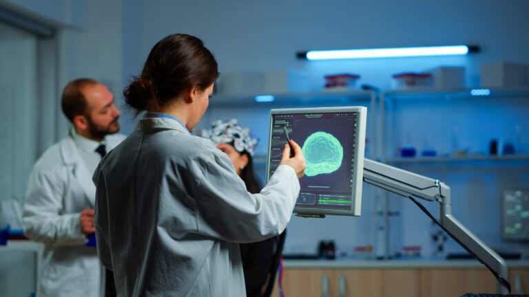 Researcher looking at monitor analysing brain scan